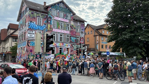 Vor dem Epple-Haus in Tübingen, das vor allem wegen seiner Graffity-Bemalung auffällt, haben sich rund 200 Menschen versammelt, um gegen die AfD zu demonstrieren.