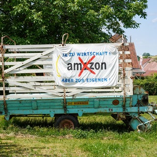 Ein Plakat an einem Anhänger, das sich gegen das geplante Amazon-Verteilzentrum bei Bad Urach richtet.