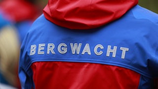 Auf einer rot-blauen Jacken steht Bergwacht geschrieben