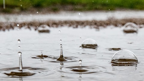 Regen fällt auf einer Straße in eine Pfütze (Symbolbild). In Spaichingen ermittelt die Polizei wegen Diebstahls, weil Regenwasser gestohlen wurde.