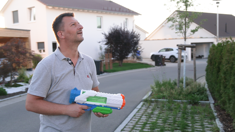 Michael Rani mit Wasserpistole in der Hand wegen Taubenproblem in Balinger Neubaugebiet. Tauben nisten unter Solaranlagen und verdrecken Gärten und Balkone.