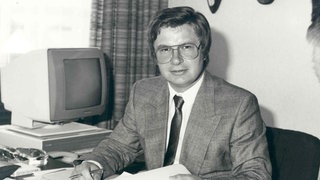 Klaus Fischer sitzt 1980 an einem Schreibtisch. Damals hat der heute 75-Jährige die Dübel- und Technikfirma Fischer in Waldachtal von seinem Vater übernommen.