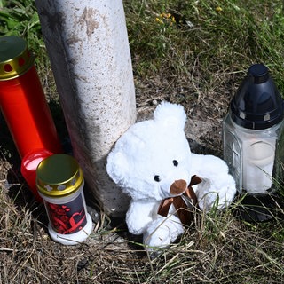 Kerzen und ein Plüschtier stehen an der Unfallstelle an einer Straße zwischen Waldachtal und Pfalzgrafenweiler: Eine Zweijährige hat überlebt und ist aus dem Koma erwacht.