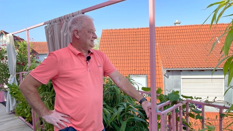 Stefan Köhler steht auf seinem Balkon im knallrosa Haus in Metzingen. Das Haus gefällt dort nicht allen. 