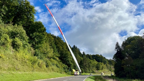 Ein über 40 Meter hohes Rotorblatt wird auf einem Transporter befördert. Durch einen Unfall ist der TRansport allerdings blockiert worden.