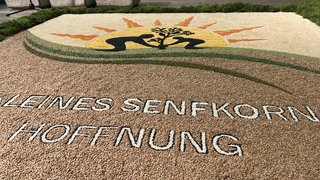 Ein kunstvoll gestalteter Erntedankteppich aus Körnern und Geürzen liegt neben dem Altar in der katholischen Kirche in Kolbingen