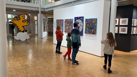 Eine Mutter mit zwei Kindern vor einem Rizzi-Gemädle in der Ausstellung im neuen Kunstmuseum Tübingen. 