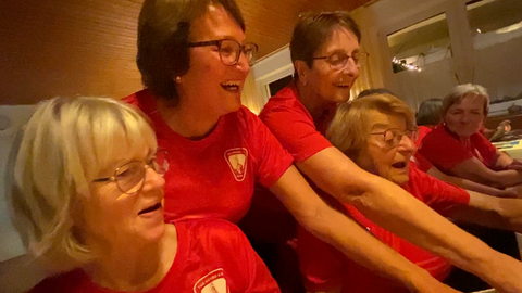 Die Leiterin der Frauengymnastikgruppe aus Lichtenstein-Honau (Kreis Reutlingen) schaut mit den anderen alte Fotos an. 