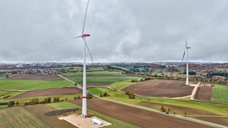 Zwei Windräder im Windpark Münsingen-Magolsheim (Kreis Reutlingen) ragen über der Albhochfläche in den Himmel.