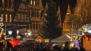Weihnachtsmarkt mit beleuchteten Fachwerkhäusern und Menschenmenge 