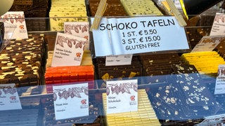 Preisschild an einer Auslage mit vielen bunten Tafeln Schokolade auf dem Schokomarkt chocolART in Tübingen.