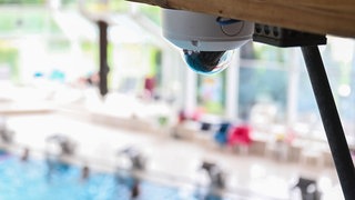 Eine Videokamera an der Holzdecke des Panoramabads in Freudenstadt. Mit dieser und weiteren Kameras will das Schwimmbad durch eine KI-gestützte Videoüberwachung mittels einer Smartwatch überwachen, wenn etwa ein Becken überfüllt ist. 