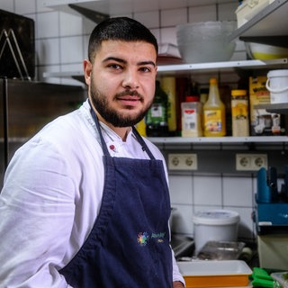 Ein junger Mann steht mit einer Schürze in einer Großküche. Der Asylbewerber Hussain Salan hat im Hechinger Refugio als Koch gearbeitet (Archivbild).
