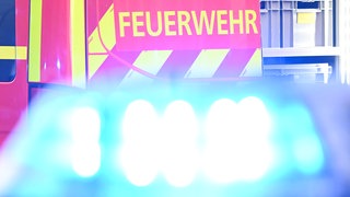 Ein Feuerwehrauto ist im Hintergrund zu sehen, davor das Blaulicht eines Polizeiautos. Ein Mann wurde bei einem Brand in Loßburg schwer verletzt.