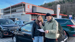 Eden und Xenia Volohonsky blicken auf einem Parkplatz in Horb auf das Schreiben mit Zahlungsaufforderung, das sie von Nexobility geschickt bekommen haben. 