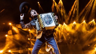 Im goldenen Bühnenlicht spielt Eduardo Hernandez Akkordeon