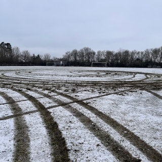 Reifenspuren ziehen sich über den zerstörten Sportplatz in Seebronn