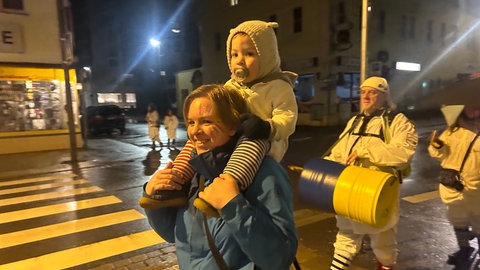 Am Schmotzingen Donnerstag wecken die Narren in Nachthemden um sechs Uhr morgens die Stadt. Der Narren-Nachwuchs darf auf der Schulter sitzen, während die anderen Narren trommeln. 