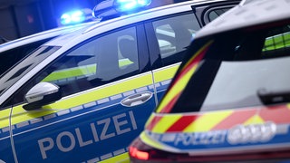 Zwei Streifenwagen mit Blaulicht der Polizei baden-Würtemberg stehen nebeneinander.