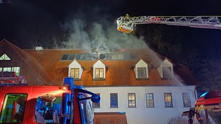 Ein brennendes Haus in Starzach. Die Feurwehr löscht mit einer Drehleiter den Dachstuhl.