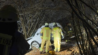 Ein weißes Auto wird mit einem Seil von der Feuerwehr aus den Bäumen gezogen. Unfall in Albstadt-Ebingen und der Fahrer ist verschwunden.