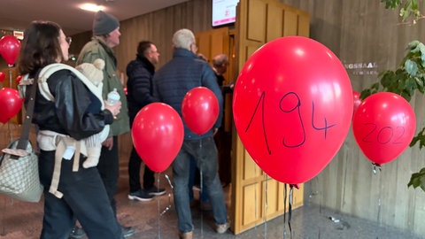 Durchnummerierte rote Luftballons hängen verteilt im Foyer zum großen Sitzungssaal. Jeder steht für eine Stelle die mit dem neuen Haushalt wegfällt 