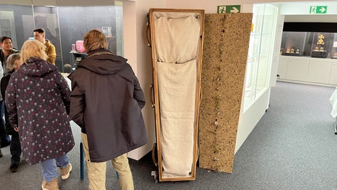 In einem Ausstellungsraum steht ein Sarg aufgestellt an der Wand. Er ist Teil einer Ausstellung im Museum für Volkskunst in Meßstetten.