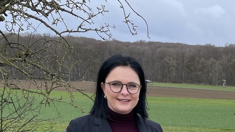 Bürgermeisterin Anja Sauer aus Römerstein steht vor einer Wiese und lächelt in die Kamera. Sie war Kandidatin bei der OB-Wahl in EislingenFils.