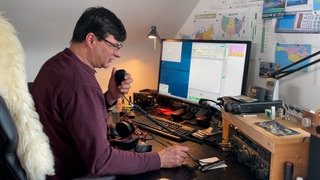 Amateurfunk als Hobby: Denis Mrša aus Balingen hat Funk-Mikrofon in der Hand und versucht mit jemandem in der Ferne zu sprechen.