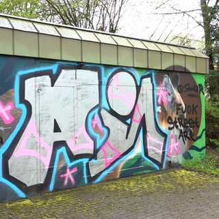 An einem Gebäude der Stadtwerke Tübingen wurde Graffiti über ein Auftragsbild gesprüht. Das Bild ist nicht mehr zu erkennen. Es steht dort jetzt ein Schriftzug: "Fuck Street Art".