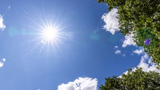Die Sonne scheint bei blauem Himmel und wenigen Wolken. Das Risiko für Hautkrebs ist bei Männern ist besonders hoch.
