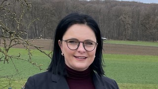 Bürgermeisterin Anja Sauer aus Römerstein steht vor einer Wiese und lächelt in die Kamera. Sie war Kandidatin bei der OB-Wahl in EislingenFils.