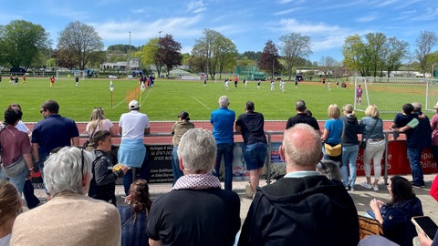 Totale auf die Spielfelder beim Bentley-Cup. Im Vordergrund stehen einige Zuschauer an der Bande. Der Bentley-Cup ist ein hochkarätig besetztes U10 Jugendfußball Turnier mit Mannschaften aus Europa.