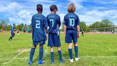 Drei Spieler der U10 Jugendmannschaft von 1860 München stehen am Spielfeldrand und warten auf ihren Einsatz. Der Bentley-Cup ist ein hochkarätig besetztes U10 Jugendfußball Turnier mit Mannschaften aus Europa.