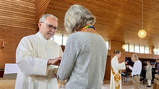 Rückert legt einer Frau eine Hostie in die Hand. Der frühere Landrat des Kreises Freudenstadt, Klaus Rückert, bei seiner ersten Predigt als Diakonenanwärter.