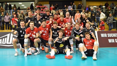 Gruppenfoto der Volleyball Männer vom TV Rottenburg nach einem gewonnenen Spiel.
