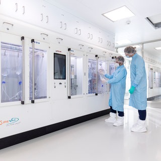 Zwei Beschäftigte im ehemaligen CureVac-Unternehmen stehen vor dem mRNA-Reprinter in Tübingen. Nun bangen sie um ihre Zukunft, nachdem BioNTech die Schließung angekündigt hat.