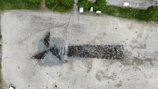 Mehr als 1.200 Teilnehmer bilden ein "Lebendiges Windrad" auf dem Tübinger Festplatz.