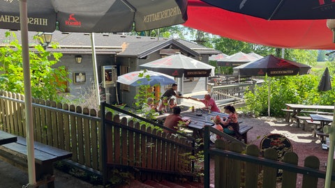In einem Biergarten sitzen sieben Leute um einen Tisch herum und werden bedient. In der Kirchbühlhütte in Mahlstetten kann man sich auch an heißen Tagen erfrischen.