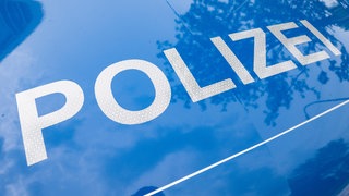 Weißer Schriftzug "Polizei" auf dem blauen Untergrund eines Dienstwagens - in Metzingen hat die Polizei einen Dreijährigen in einem Saftfass gefunden