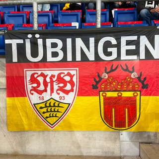 Eine Deutschland-Flagge ist im Stadion aufgehängt. Darauf zu sehen: Ein großer Tübingen-Schriftzug, das Stadtwappen und das Logo des VfB.