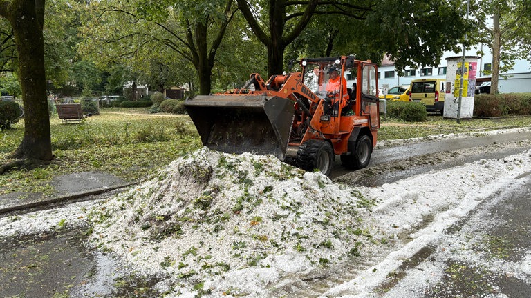 Ein Mitarbeiter der Stadt beseitigt Hagel mit einem Winterdienstfahrzeug in Reutlingen nach dem schweren Unwetter am Morgen.