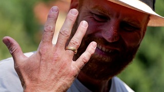 Eine Hand mit Ehering am Ringfinger. Jonas Hörrmann strahlt. Er hat den Ring im Neckar bei Tübingen verloren und wieder gefunden