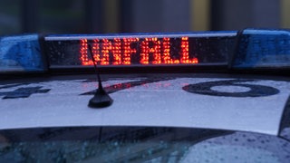 Der Schriftzug "Unfall" ist neben dem Blaulicht auf dem Dach eines Polizeiautos zu lesen.
