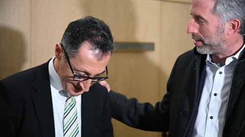 Tübingens OB Boris Palmer (parteilos) klopft Ministerpräsident Özdemir (Grüne) auf die Schulter.