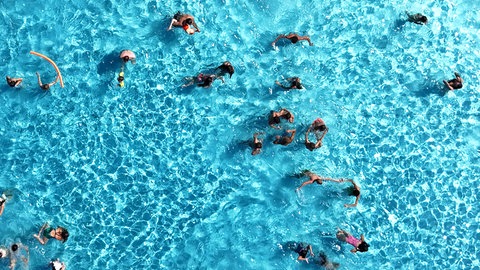 Luftaufnahme von einem Pool mit Menschen, die schwimmen.