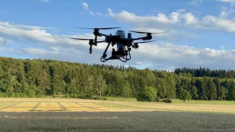 Eine Drohne der Firma K-Drones (Bad Schussenried) fliegt zur Aussaat über dem Versuchsfeld in St. Johann (Kreis Reutlingen)