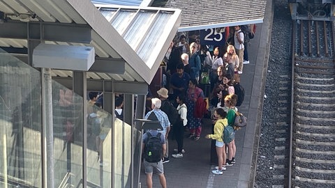 Fahrgäste stehen auf den Bahnsteigen am Ulmer Hauptbahnhof, nachdem der ICE 266 wegen einer Bombendrohung geräumt wurde.