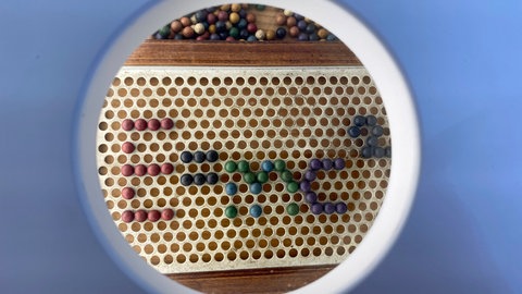 Etwas versteckt in der ersten Vitrine: das Kinderspiel mit Holzperlen aus dem Besitz der Familie Eintstein, mit dem der kleine Albert vielleicht selbst sogar gespielt hat. 