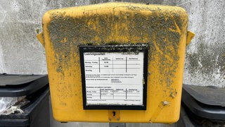 Ein gelber, mit Schmutz überzogener Briefkasten der Deutschen Post steht zwischen mehreren Mülltonnen: Dieser Briefkasten am Eichberg in Ulm wurde wochenlang nichtb geleert. Mehr als 200 Einladungen der Gesellschaft der Donaufreunde im Vorfeld der Lichterserenade am Schwörwochenende kamen deshalb nicht an.